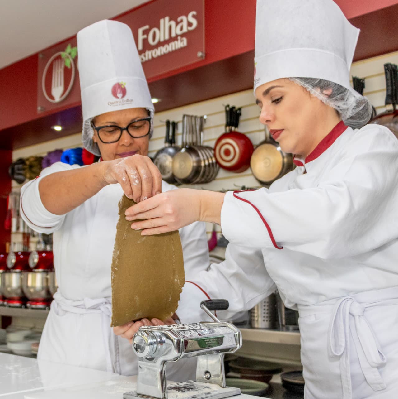 Alunas da Quatro Folhas preparando massa durante uma aula prática